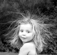 ασπρόμαυρη φωτογραφία κοριτσιού με μακριά ανοιχτόχρωμα μαλλιά που έχουν ηλεκτριστεί και πετάνε