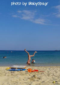 παιδί που κάνει κατακόρυφο στην παραλία